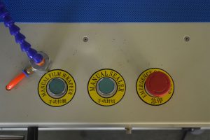 A450 automatický balicí stroj do smršťovací fólie: balík projíždí fólií a je svařen z boku a na koncích